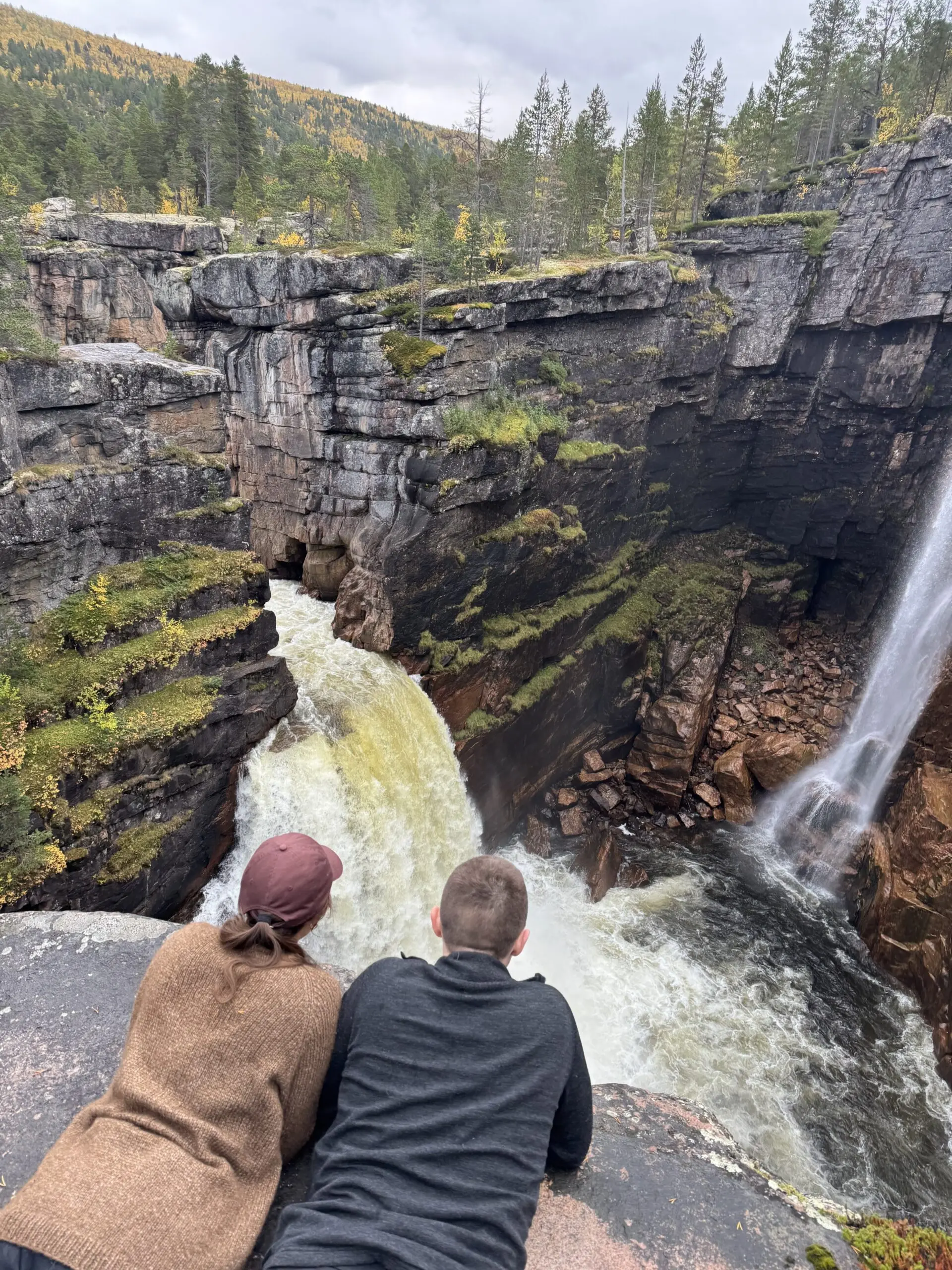 Two people looking down into the Imofossen waterfall and canyon in Reisa National Park